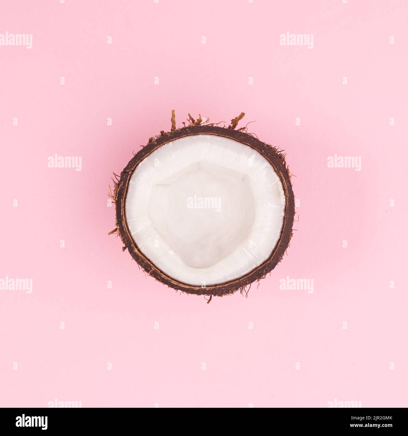 Halb Bio-frische Kokosnuss auf pastellrosa Hintergrund. Flach liegend Stockfoto