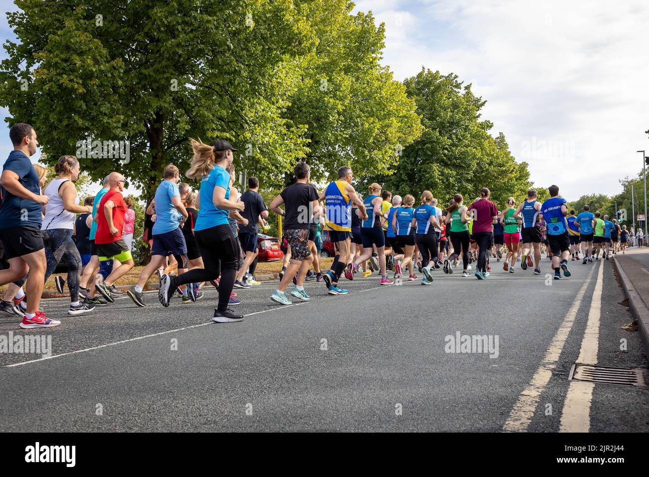 Birchwood, Warrington, Ches hire, England, Großbritannien - Sonntag, 21. August 2022 - das Birchwood 10K Laufevent 39. begann im Birchwood Shopping Center und die Läufer traten auf teilweise gesperrten Straßen an. Die Läufer gehen die Straße hinunter, um das Rennen zu beginnen. Die Mission ist es, dieses 10K-Rennen zum grünsten Rennen im Nordwesten zu machen, mit Holzveredelungsmedaillen, den Plastikeinsatz zu reduzieren und alles zu recyceln, was sie können. Das Rennen wird den Mersey Forest unterstützen, indem es Gelder für das „10 Million Trees Project“ spendet. Quelle: John Hopkins/Alamy Live News Stockfoto