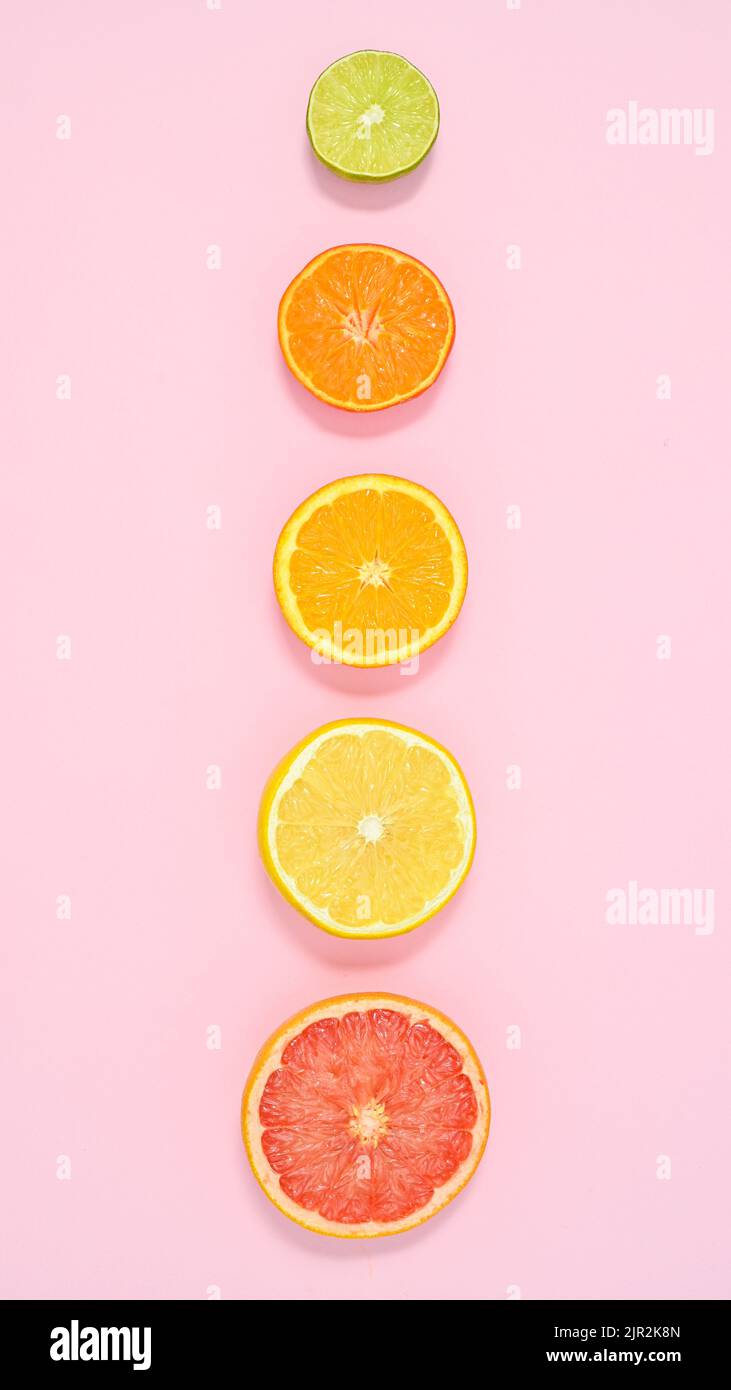 Kreative Sommer Früchte pastellrosa Hintergrund mit geschnittenen Zitrusfrüchten. Flat Lay-Konzept Stockfoto