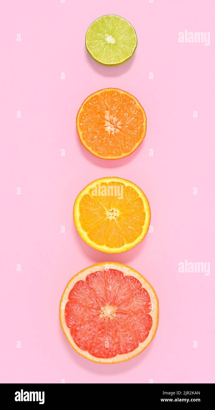 Kreative Sommer Früchte pastellrosa Hintergrund mit geschnittenen Zitrusfrüchten. Flach liegend Stockfoto