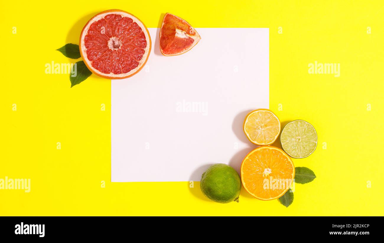 Gelber Hintergrund mit Papierkarte Kopierraum und cotrus Früchte. Flach liegend Stockfoto