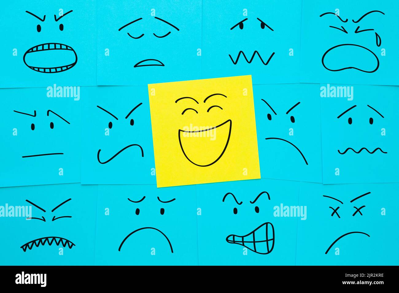 Gesichter mit unterschiedlichen Emotionen, die auf Haftnotizen gezeichnet sind. Konzept über positive Einstellung, Kundenzufriedenheit, Glück. Stockfoto
