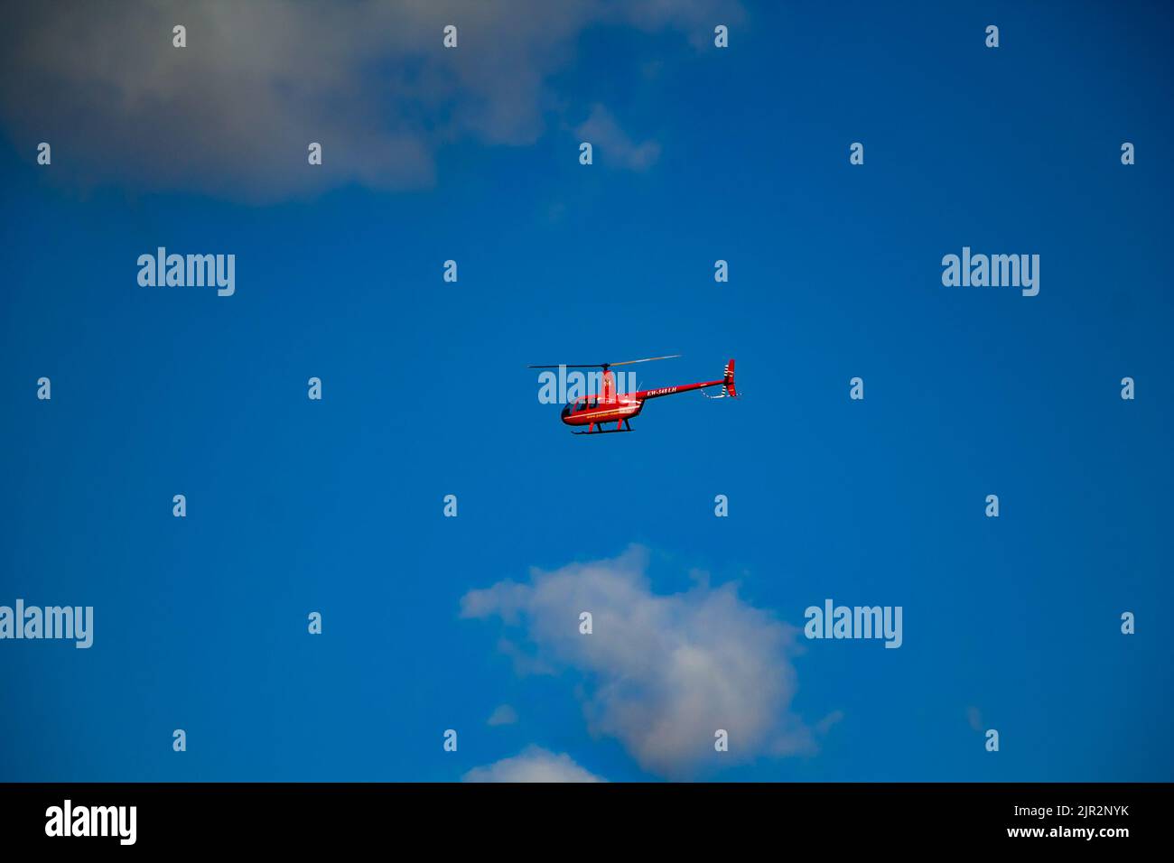 Privater Genuss roter Hubschrauber fliegt in den Himmel an einem sonnigen Sommertag. Lida, Weißrussland - 29. August 2017. Stockfoto