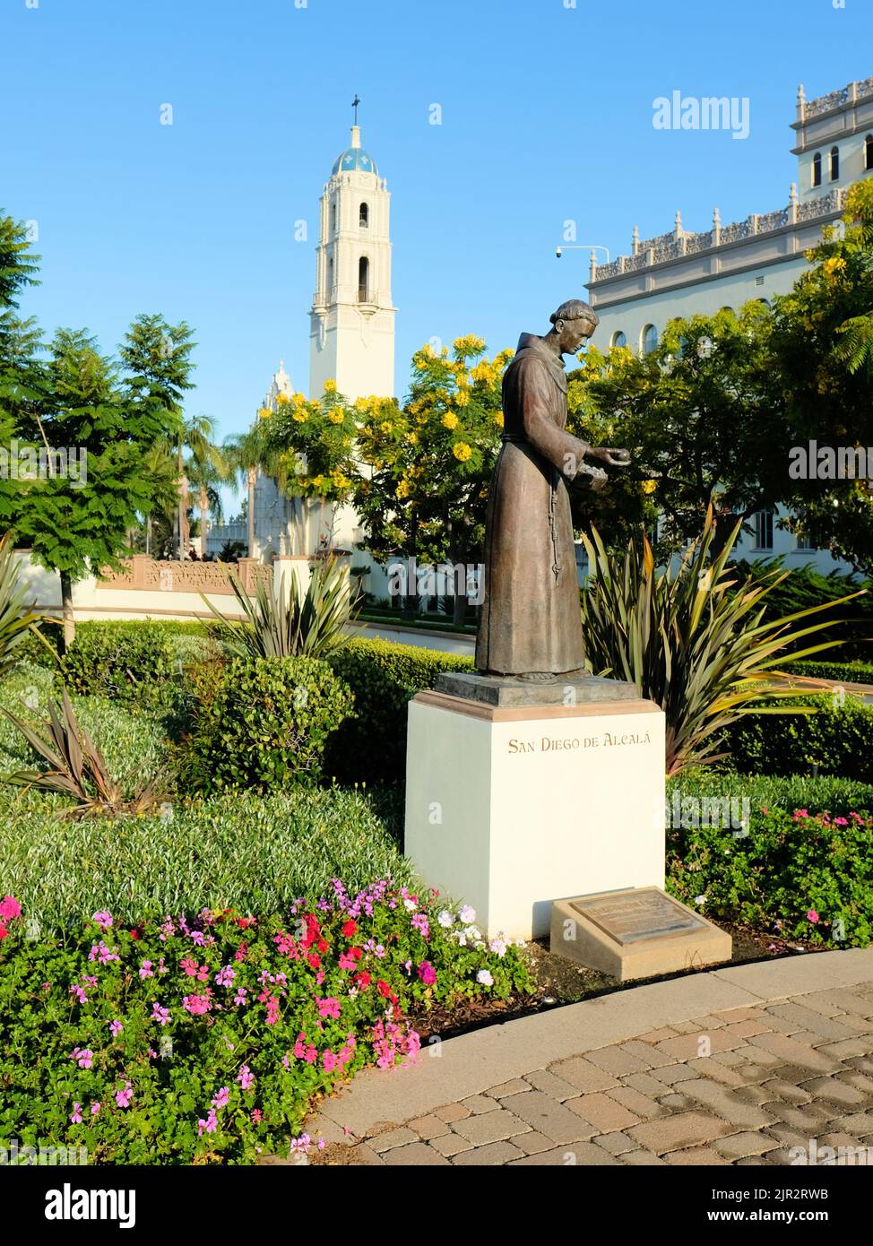 Bronzestatue von San Diego de Alcala auf dem Campus der University of San Diego, in San Diego, Kalifornien; im Hintergrund der Turm der Immaculata Parish. Stockfoto