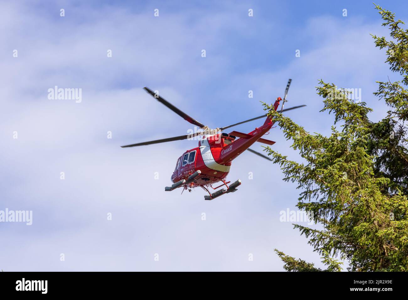 Canadian Coast Garde Helikopter an einem sonnigen Sommermorgen fliegen und fliegen. Stockfoto