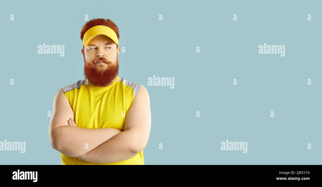 Fat Mann steht auf blauem Copy Space Hintergrund und denkt an seine Fitness-Workouts Stockfoto