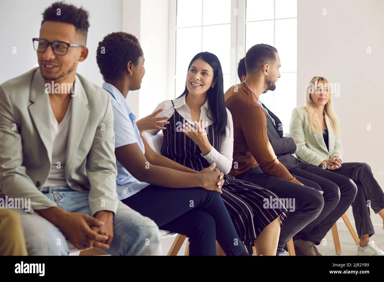 Multiethnische Gruppe von Erwachsenen, die im Englischunterricht miteinander kommunizieren Stockfoto