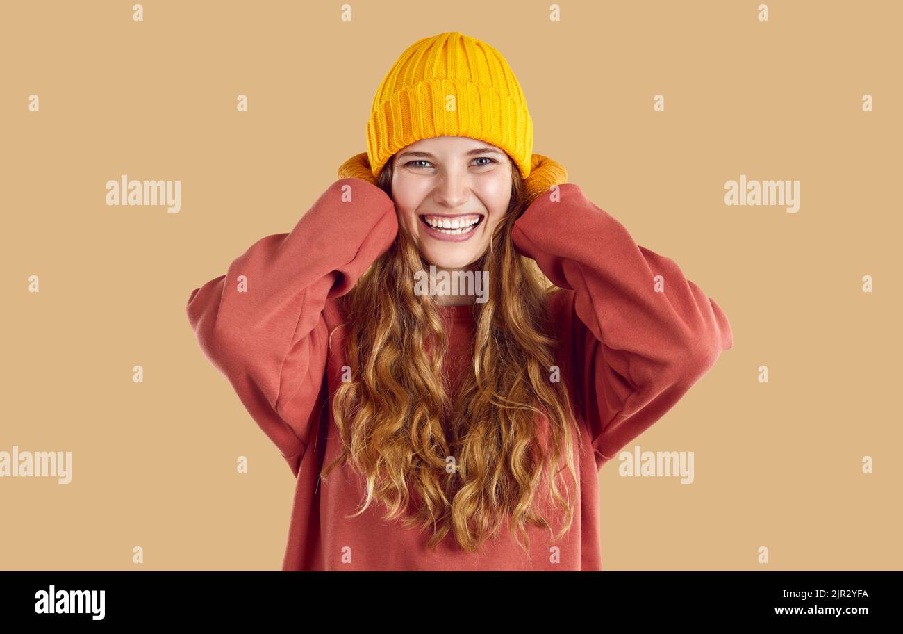 Fröhliche, fröhliche, schöne junge Frau, die warmes Herbst-Sweatshirt, Hut und Fäustlinge trägt Stockfoto