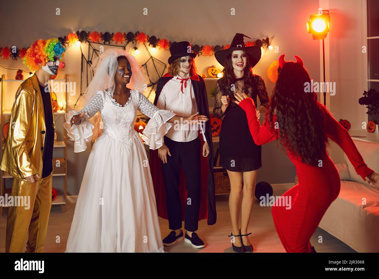 Eine Gruppe glücklicher erwachsener Freunde in gruseligen Kostümen treffen sich auf der Halloween Party Stockfoto