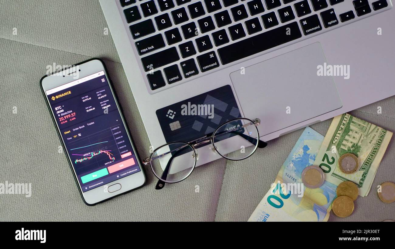 Laptop und Telefon, um Bitcoin auf der Binance Krypto-Börse während des Marktabsturzes zu kaufen. Trading, Spot, Staking. Freelance-Flatlay für den Arbeitsbereich Stockfoto