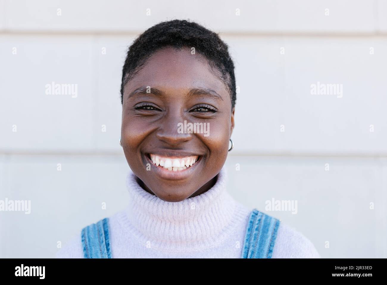 Porträt einer glücklichen jungen erwachsenen afrikanischen Frau, die im Freien vor der Kamera lächelt Stockfoto