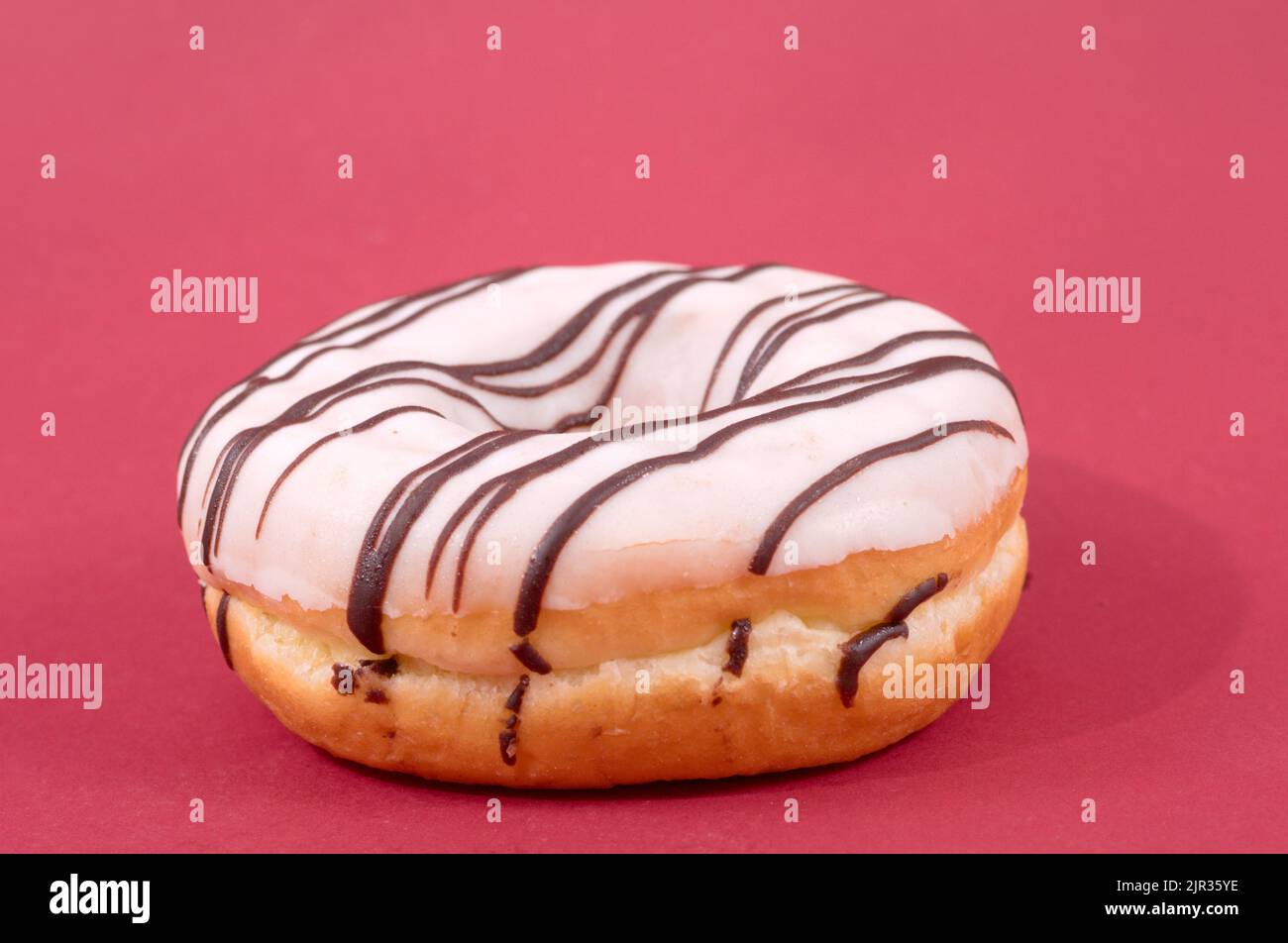 Glasierte süße Donut auf rotem Hintergrund Stockfoto