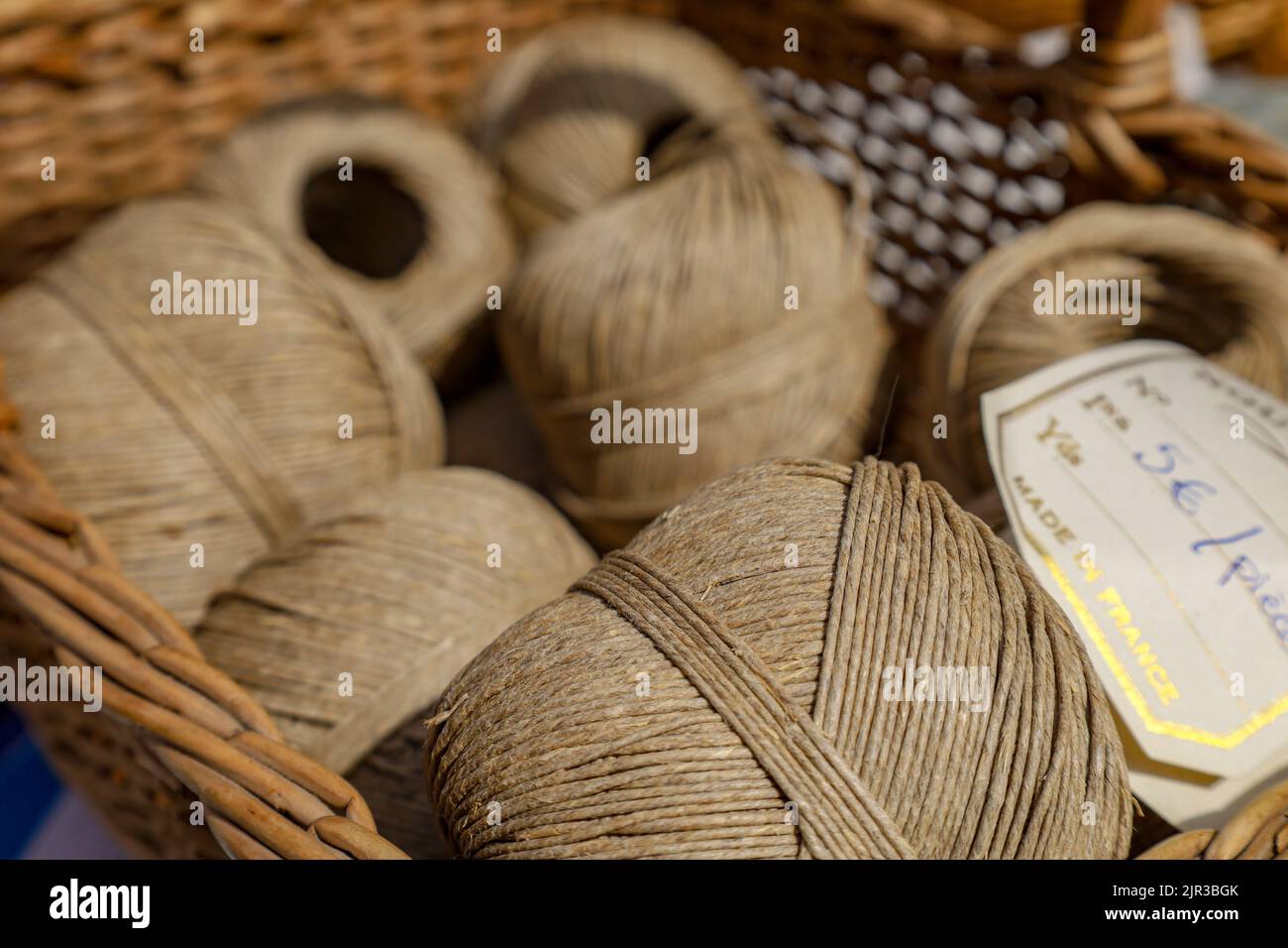 Eine Nahaufnahme beigefarbener Leinengarne in einem Korb auf einem Flohmarkt in Paris, Frankreich Stockfoto