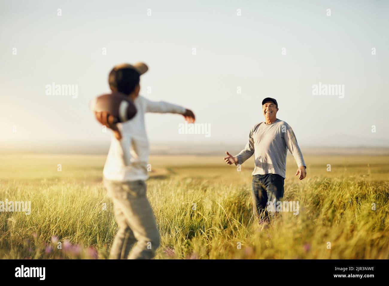 Mit unserer eigenen Bonding Session. Vater und Sohn Fußball spielen auf einem offenen Feld. Stockfoto