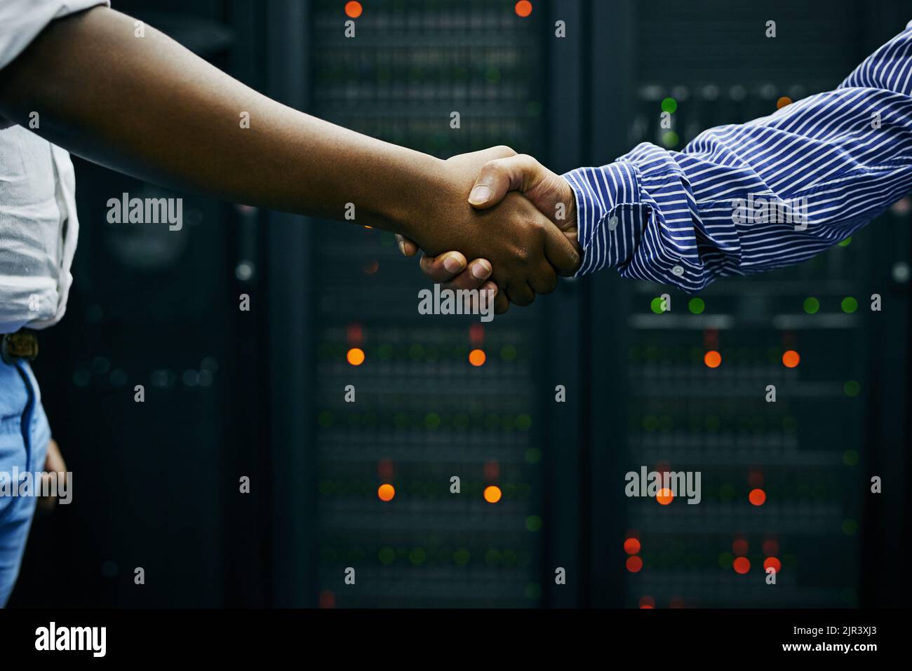 Zwei Männer, die sich in einem Rechenzentrum die Hände schütteln. Stockfoto