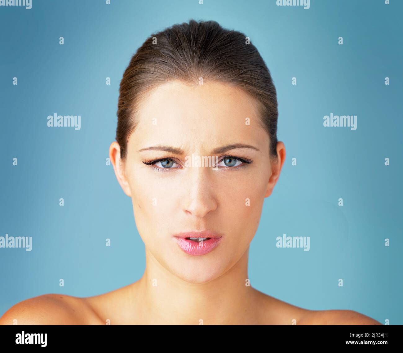 Ihr habt mir nicht gefallen. Studioporträt einer schönen jungen Frau, die vor blauem Hintergrund wütend aussieht. Stockfoto