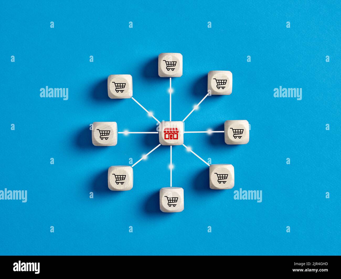 Holzwürfel mit Store- und Warenkorb-Symbolen, die mit Verbindungslinien miteinander verbunden sind. Online-Shopping, digitales Online-Marketing, Kundeninteraktionen Stockfoto