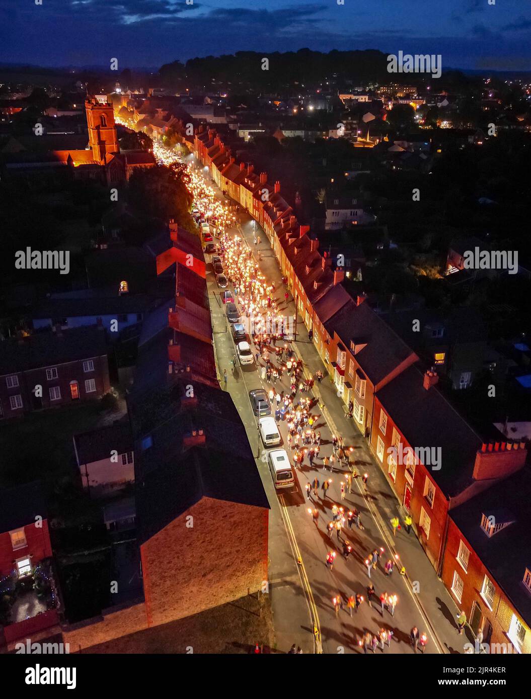 Bridport, Dorset, Großbritannien. 21.. August 2022. Blick aus der Luft, während Hunderte von Feiernden zur jährlichen Bridport Carnival Fackelparade in Bridport in Dorset kommen, die nach drei Jahren Abwesenheit aufgrund der Covid-19-Pandemie zurückkehrt. Die Fackelparade geht vom Rathaus in Bridport nach East Beach in West Bay. Bildnachweis: Graham Hunt/Alamy Live News Stockfoto