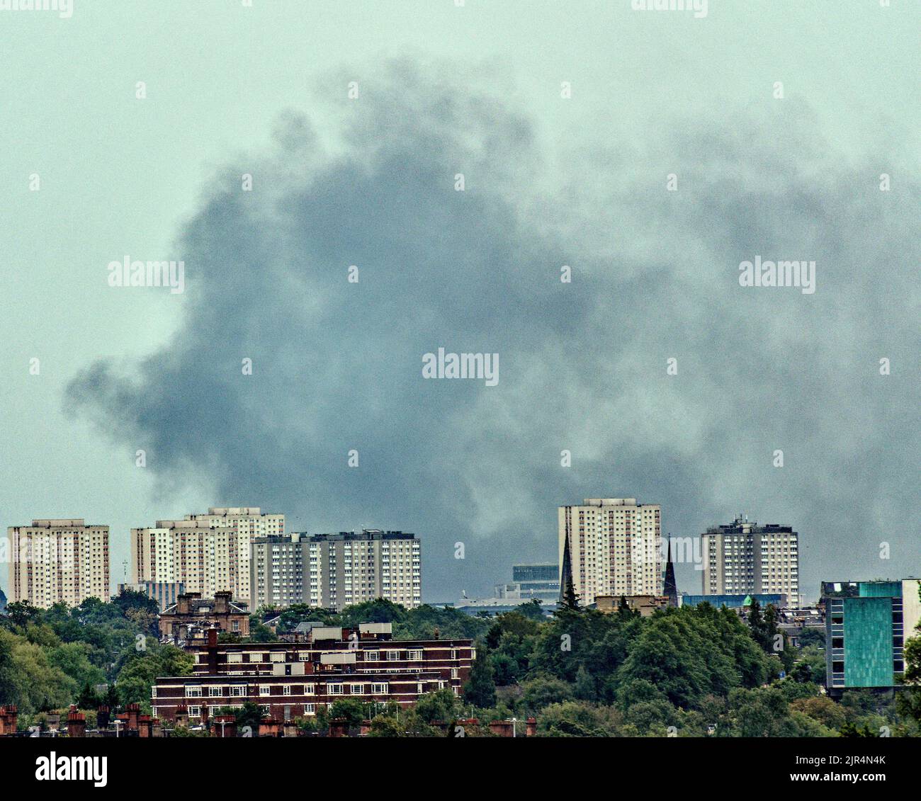 Glasgow, Schottland, Großbritannien 22.. August 2022. Am frühen Morgen hängt Rauchwolke über den Türmen des Stadtzentrums, obwohl sein Ursprung im östlichen Ende liegt. Anscheinend verursachte ein Busfeuer am M74 die Rauchwolke über der Stadt. Credit Gerard Ferry/Alamy Live News Stockfoto