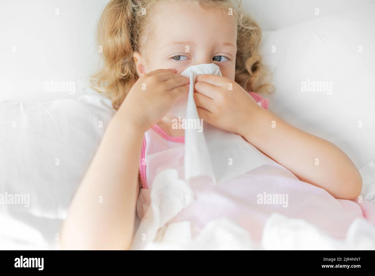 Das Kind wischt seine Nase mit einer Serviette ab. Stockfoto