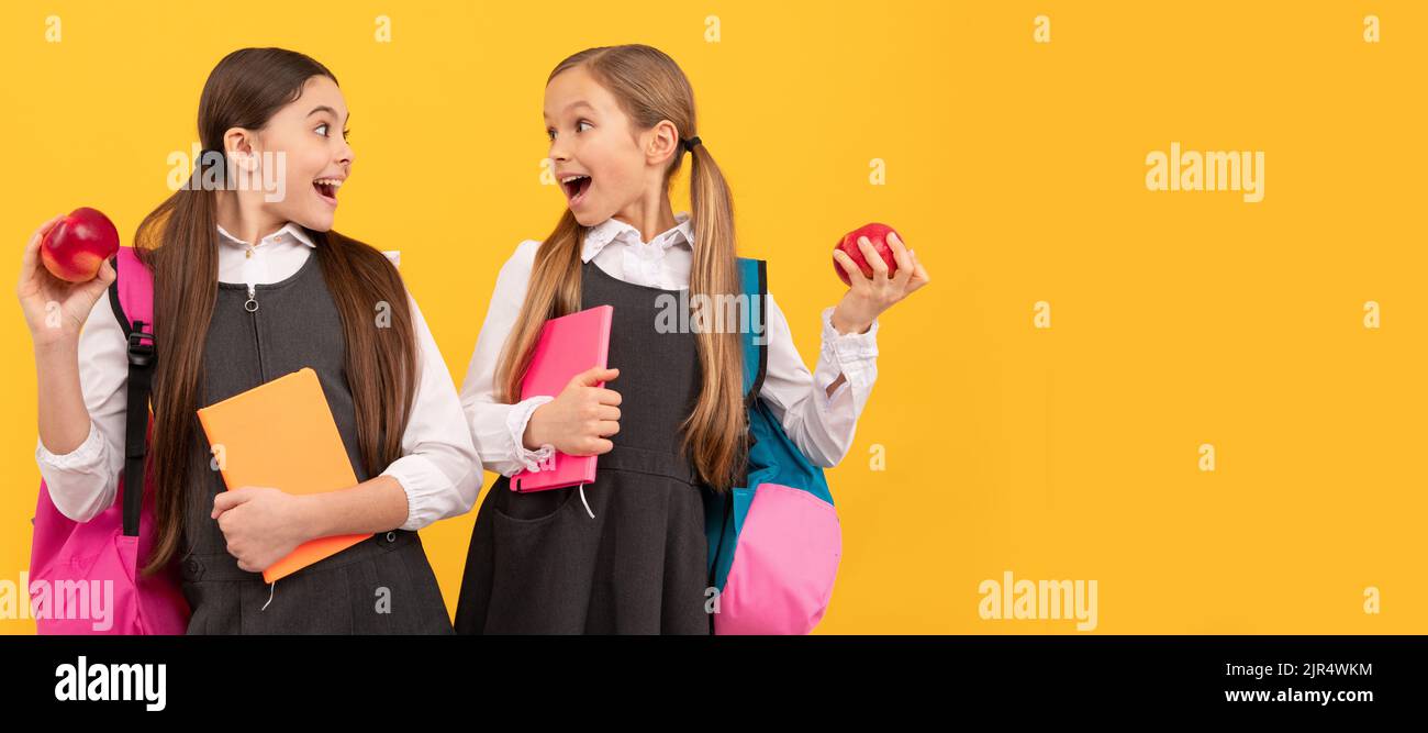 Schulmädchen Freunde. Überraschte Kinder halten Äpfel. . Horizontales isoliertes Plakat der Schülerin. Banner Header Porträt von Schulmädchen Kopie Stockfoto