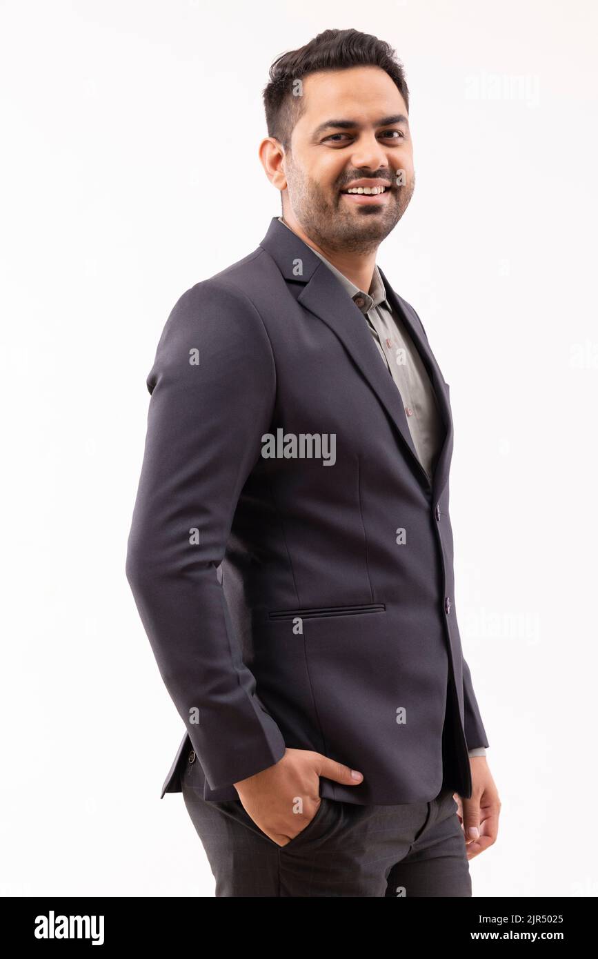 Porträt eines fröhlichen jungen Geschäftsmannes, der die Kamera mit der Hand in der Tasche anschaut Stockfoto