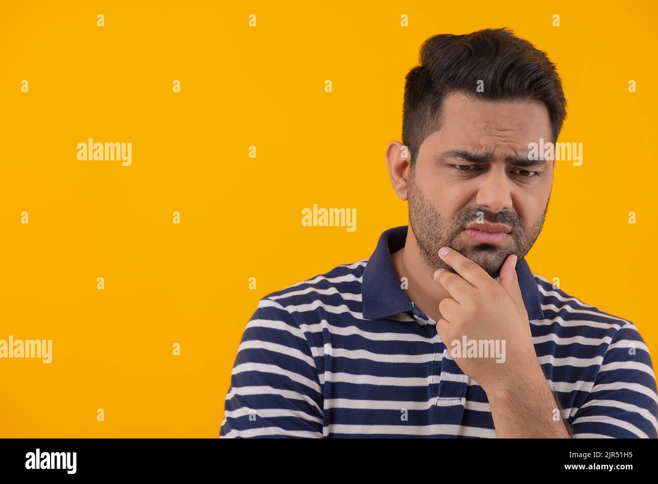 Porträt eines frustrierten Mannes mit der Hand am Kinn Stockfoto