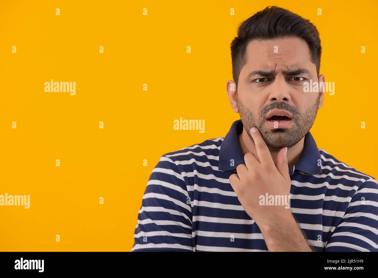 Porträt eines überraschten Mannes mit der Hand am Kinn Stockfoto