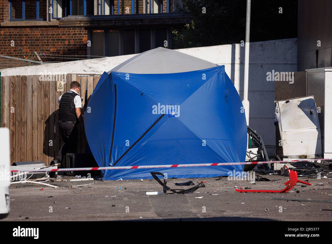 London, Großbritannien. 22. August 2022. Polizeibeamte nutzen ein Zelt, um eine Leiche auf einem Tesla-Vorplatz im Showroom im Park Royal, West-London, zu bedecken, wo die A40 geschlossen und die Piccadilly-Linie suspendiert wird, nachdem eine Frau bei einer Kollision mit zwei Autos, einem Range Rover und einem Tesla, gestorben ist. Der Range Rover hatte die Straße verlassen und auf die Eisenbahnlinie gefahren. Bildnachweis: Ben Cawthra/Sipa USA **KEINE Verkäufe in Großbritannien** Bildnachweis: SIPA USA/Alamy Live News Stockfoto