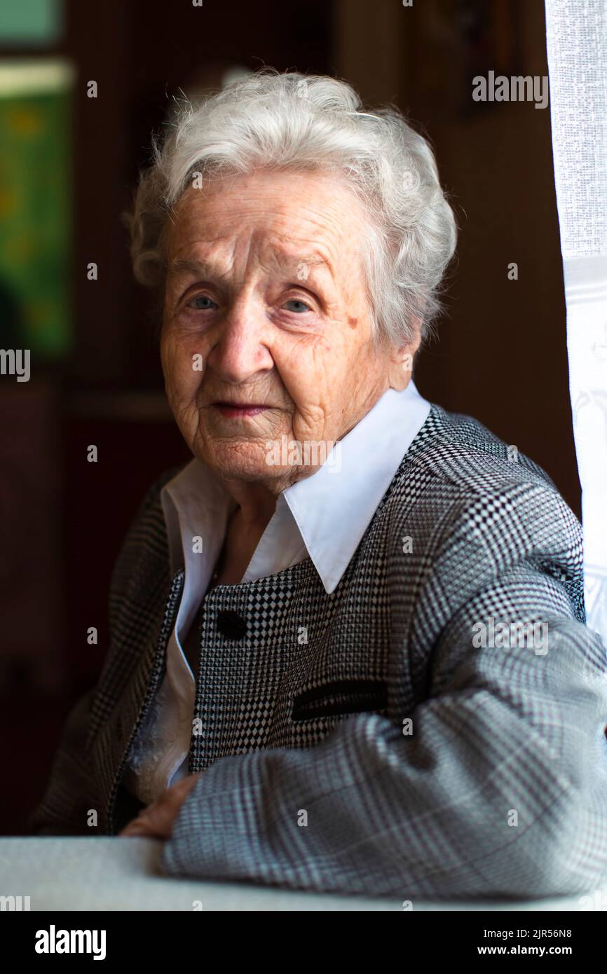 Portrait einer älteren Frau, die am Tisch sitzen. Stockfoto