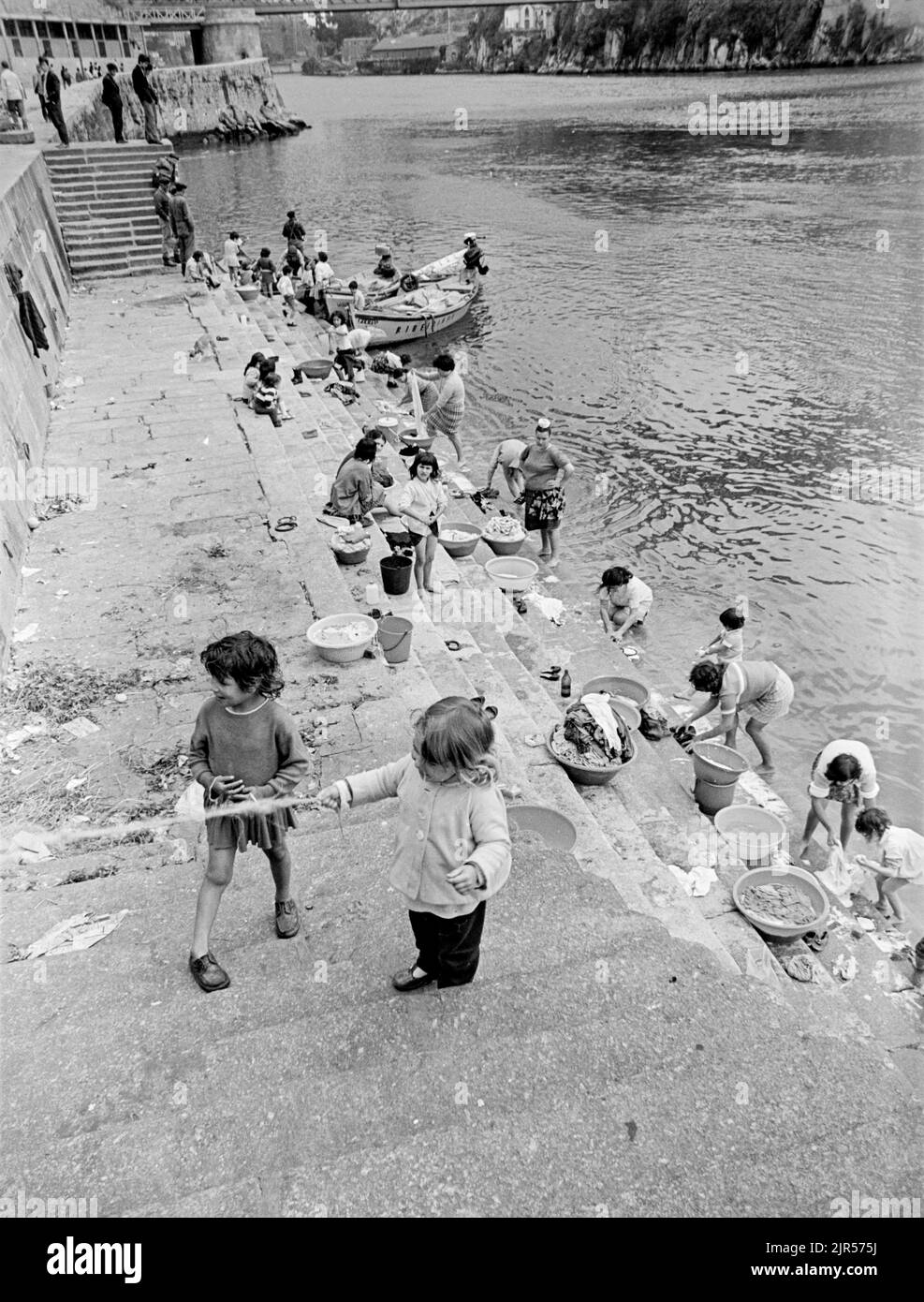 PORTUGAL - PORTO - 1970. Frauen und Kinder waschen ihre Kleidung im Fluss Douro an der Küste von Cais da Ribeira im Stadtteil Ribeira von Porto, N Stockfoto