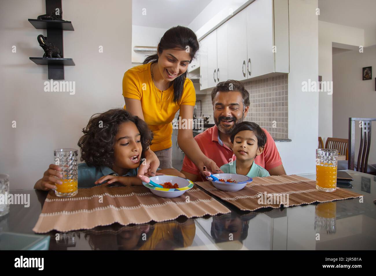 Porträt einer nuklearen Familie am Frühstückstisch im Wohnzimmer Stockfoto