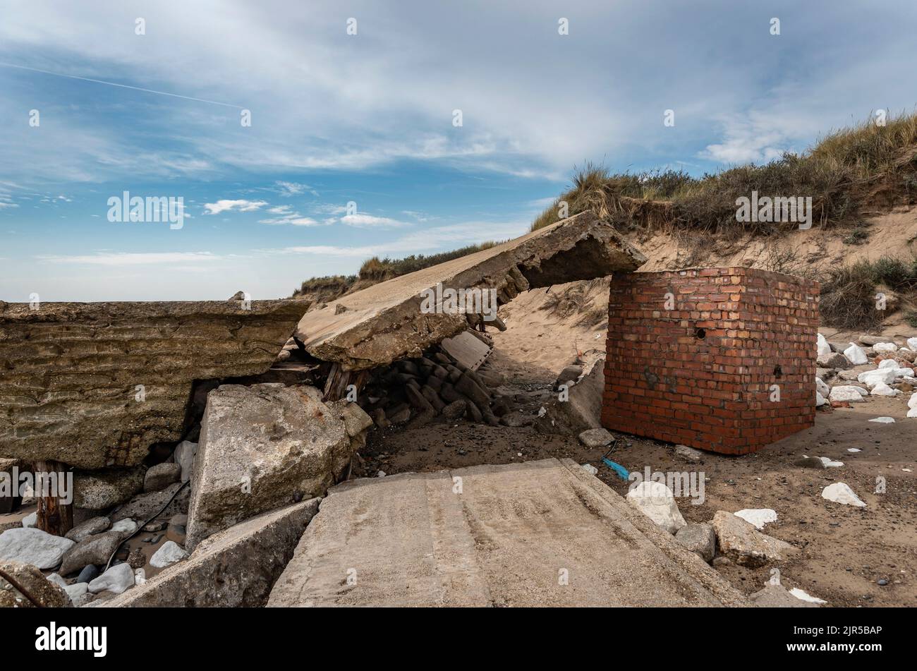 Zerstörte und erodierte Straßenbelägen und Militärgebäude auf Spurn Head, East Yorkshire, Großbritannien Stockfoto