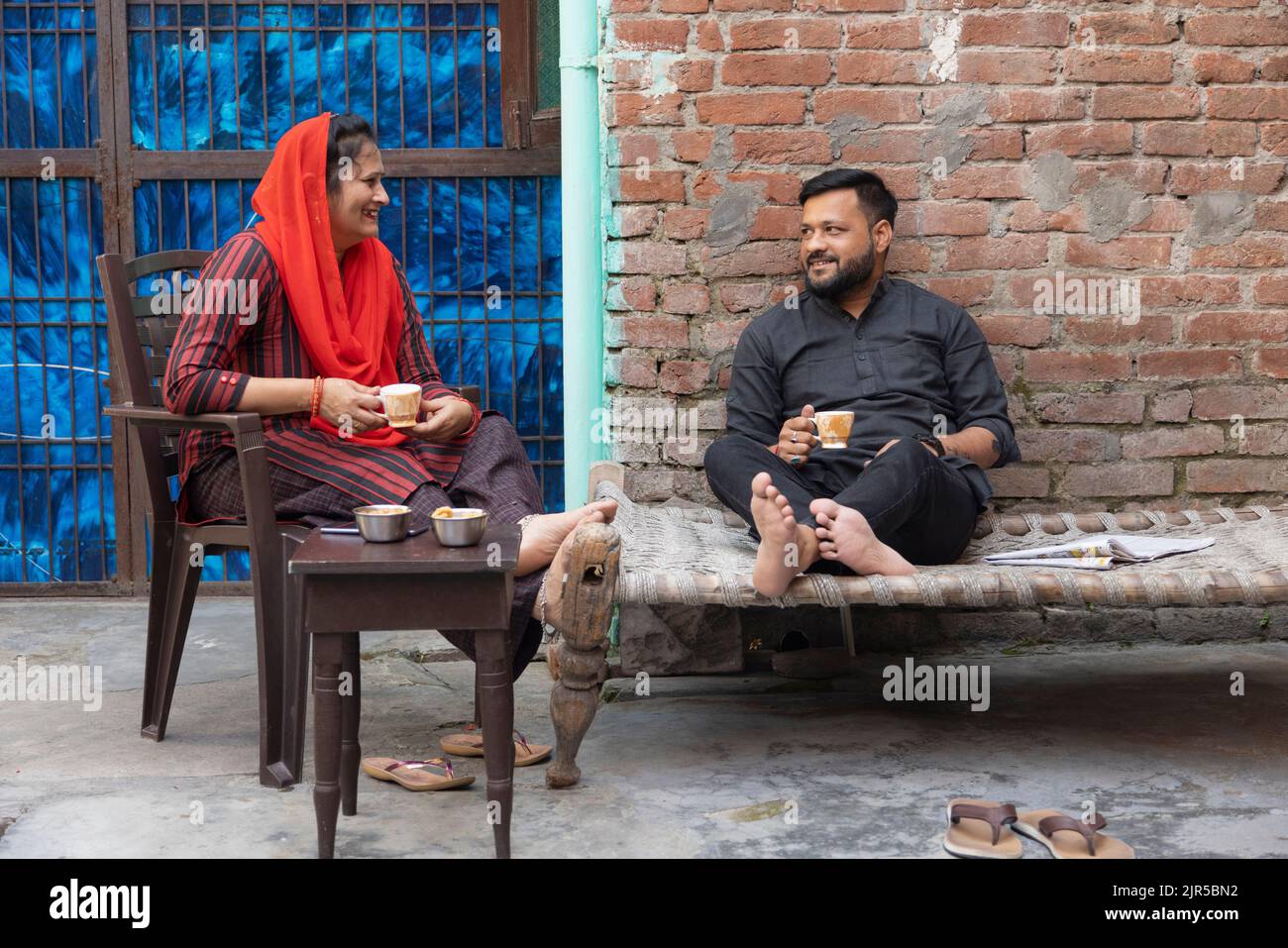 Junges Paar, das sich beim Tee im Hinterhof unterhielt Stockfoto