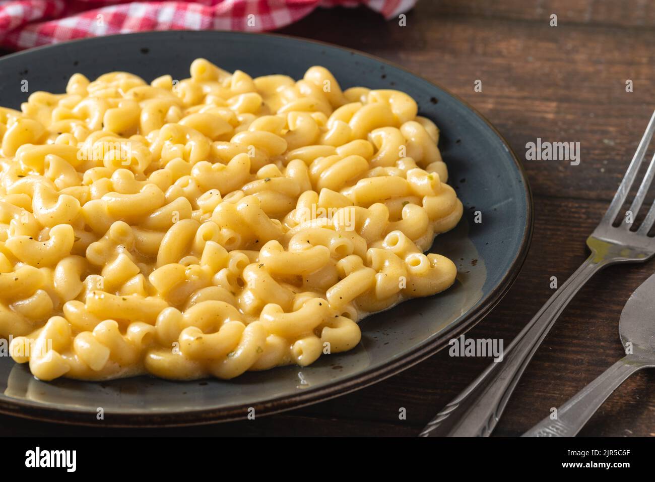 Köstlicher Mac n Käse oder Makkaroni und Käse auf einem schwarzen Porzellanteller Stockfoto