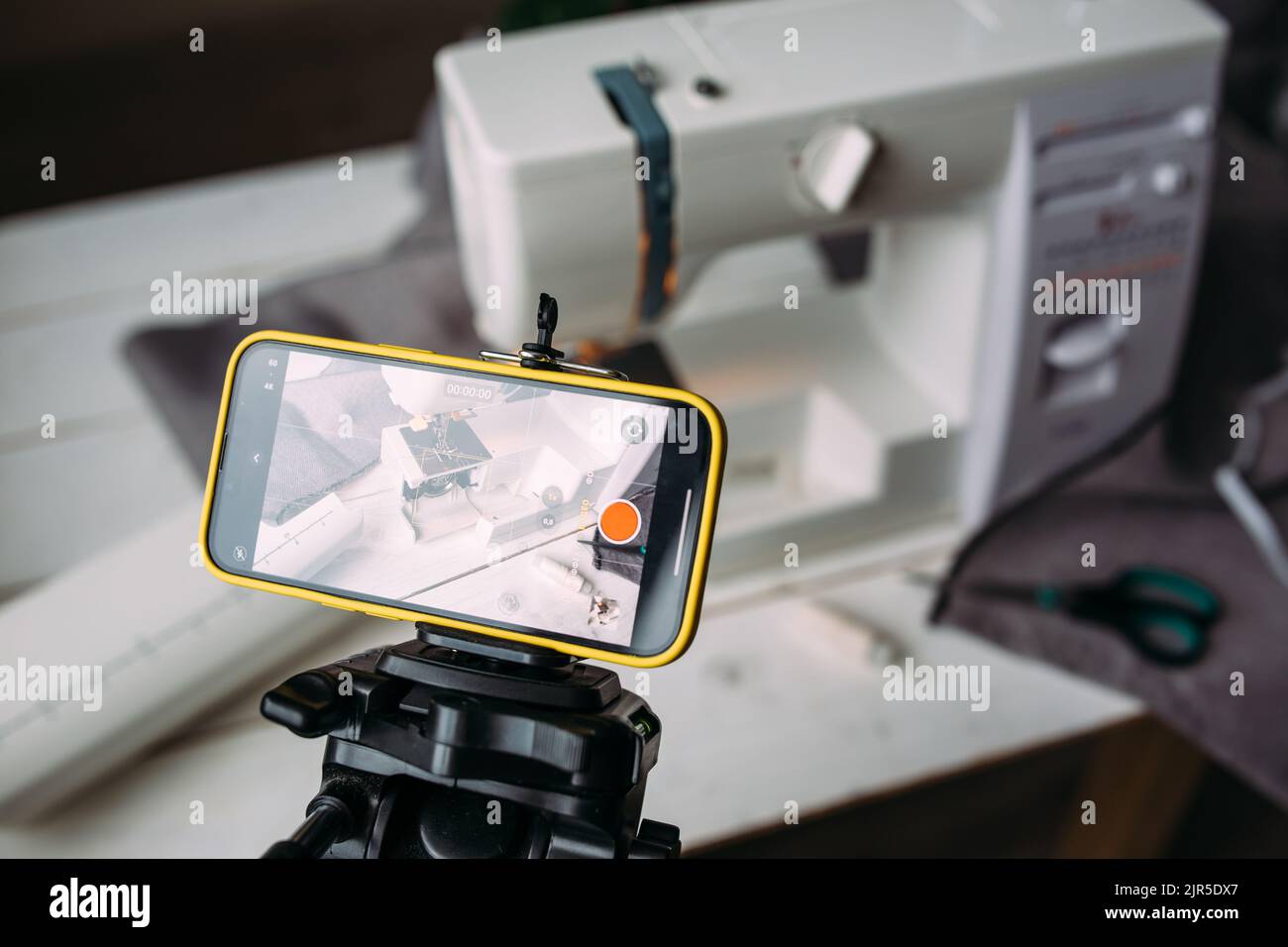 Drehvideo zum Nähprozess, Workshop zum Thema Bekleidungsdesign auf dem Smartphone Stockfoto