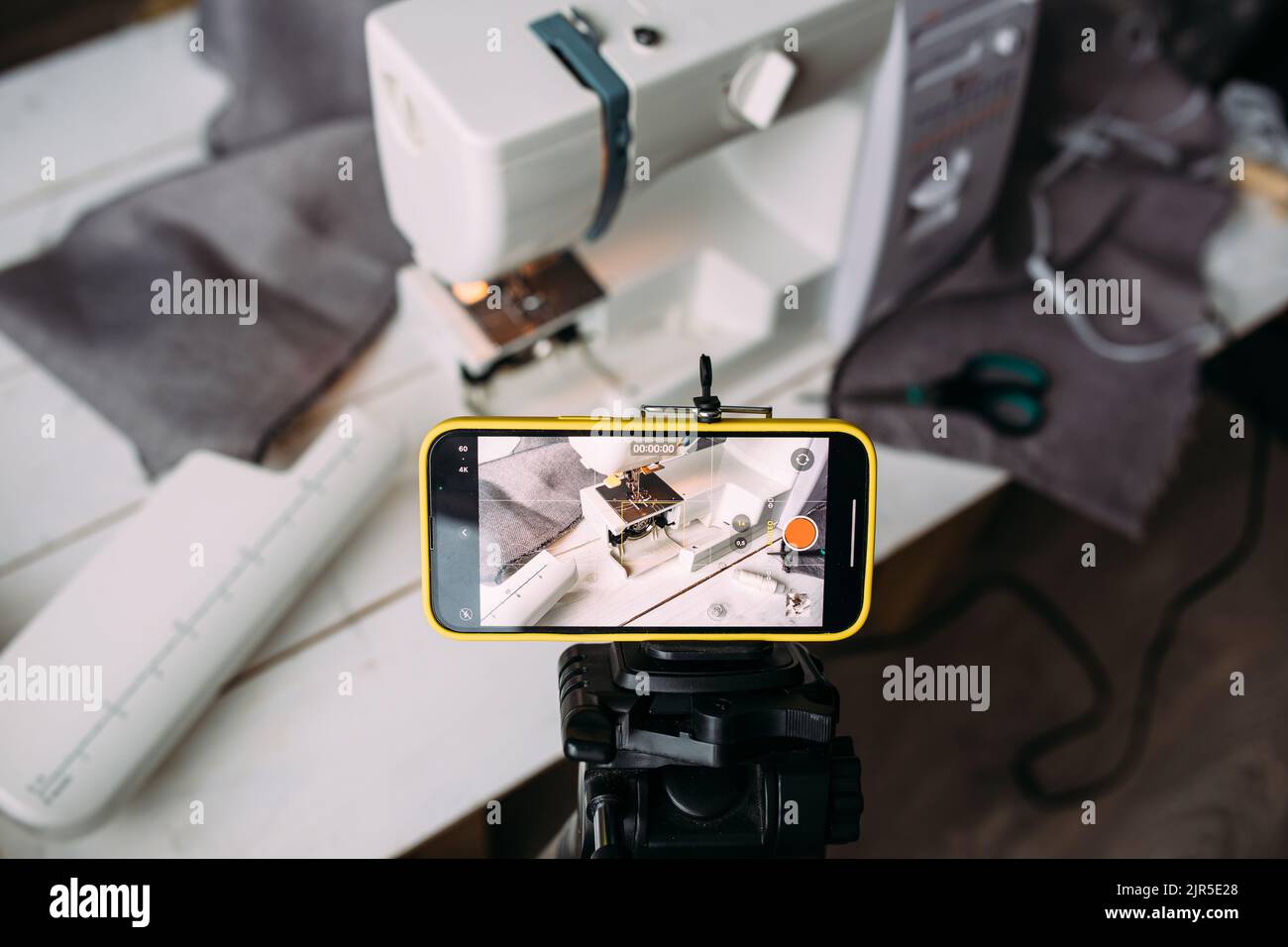 Drehvideo zum Nähprozess, Workshop zum Thema Bekleidungsdesign auf dem Smartphone Stockfoto