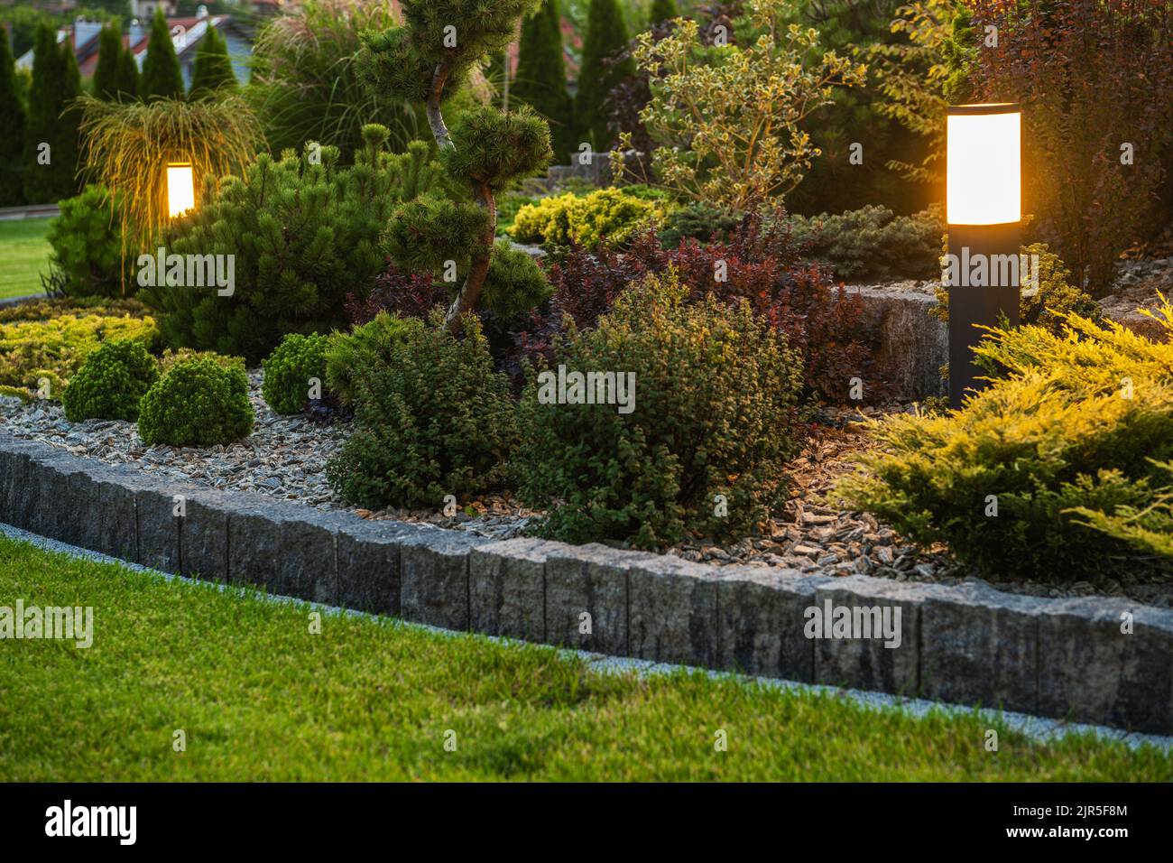 Moderne Outdoor-LED-Gartenbeleuchtung im schönen reifen Wohn-Garten. Thema Gartenarbeit und Landschaftsbau. Stockfoto