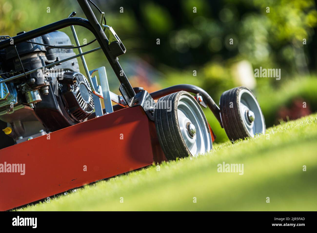 Seite eines modernen Vertikutierers oder Vertikuters auf einem Garten Rasen. Pflege Des Saisonalen Grases. Landschafts- und Gartengeräte. Stockfoto