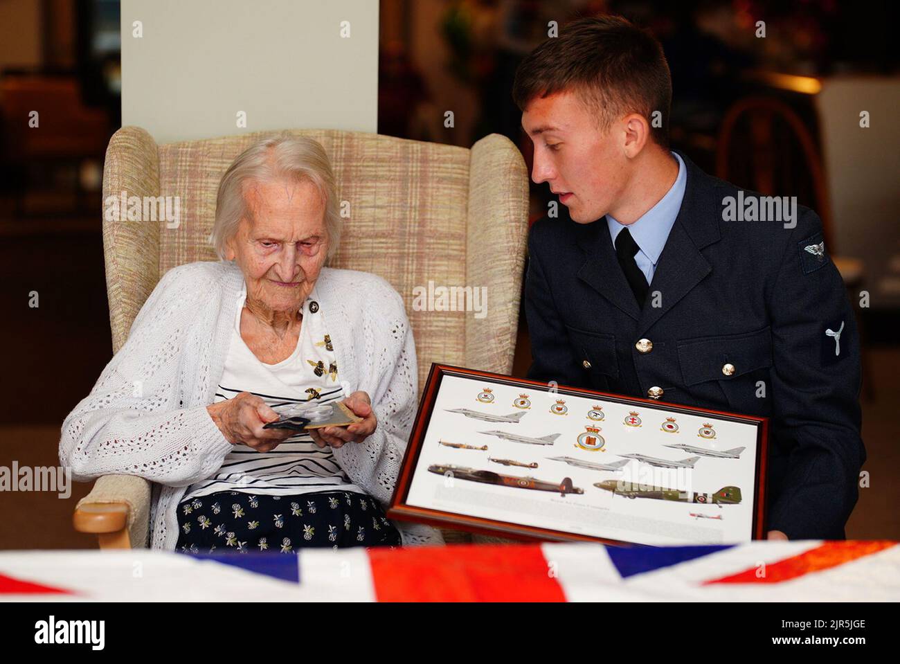 Die 99-jährige WAAF-Veteranin, Mrs. Margaret 'Peggy' Terry, wird im Gwernllwyn Care Home, Gorslas, Wales, von William Anderson, einem Air Specialist Class 1, fünf Silbershillings und ein gerahmtes Bild als Geste der Wertschätzung für ihren Dienst präsentiert, als sie während eines kürzlichen Gesprächs Sie erwähnte scherzhaft gegenüber AS1 Anderson, dass sie noch fünf Schillinge schuldete, nachdem sie die RAF 1945 verlassen hatte. Bilddatum: Montag, 22. August 2022. Stockfoto