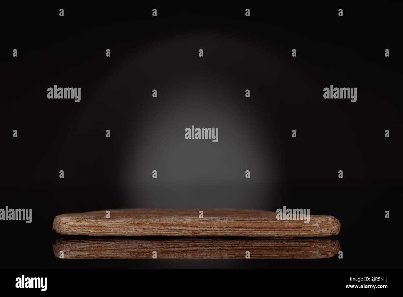 MODELL, Holzpodium, um Verpackung und Produkt auf dunkelschwarzem Hintergrund zu zeigen, Kopierraum. Stockfoto