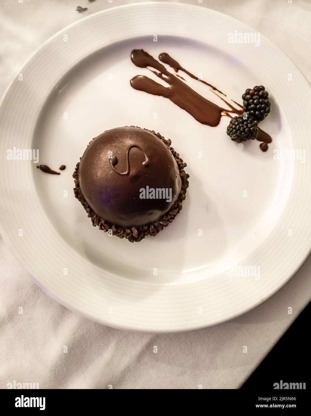 Eine runde, minimalistische Sacher-Torte auf einem weißen Teller Stockfoto