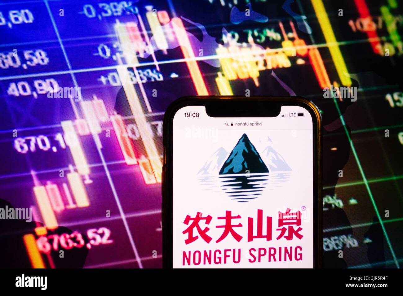 KONSKIE, POLEN - 10. August 2022: Smartphone mit Logo der Firma Nongfu Spring im Hintergrund des Börsendiagramms Stockfoto