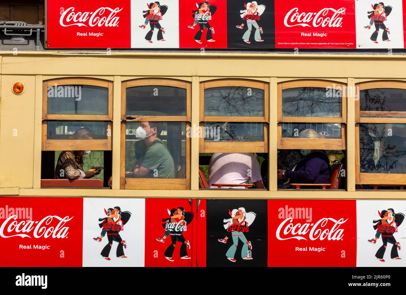 Porto Tram 205 im Stadtzentrum von Porto Portugal mit Touristen, die durch die Fenster schauen und Coca Cola Werbung auf der Seite. Stockfoto