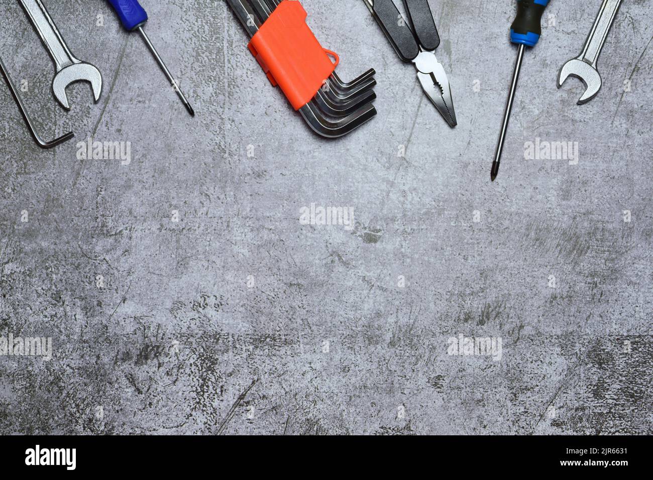 Eine Auswahl an Werkzeugen und verschiedenen, auf einem Steinhintergrund isolierten Werkzeugen Stockfoto