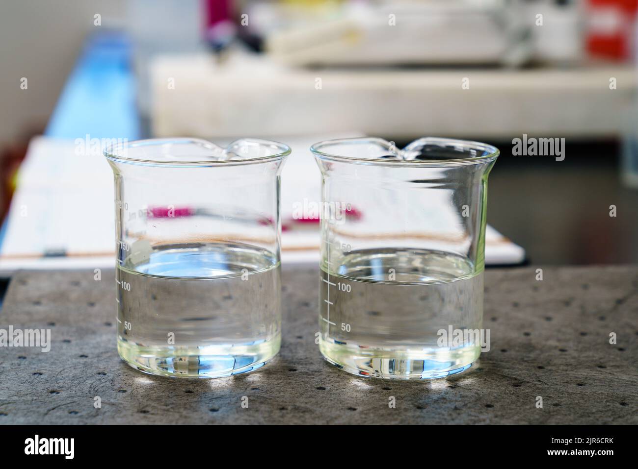 Zwei Becher mit klaren Flüssigkeiten auf einem Pad in einem Labor Stockfoto