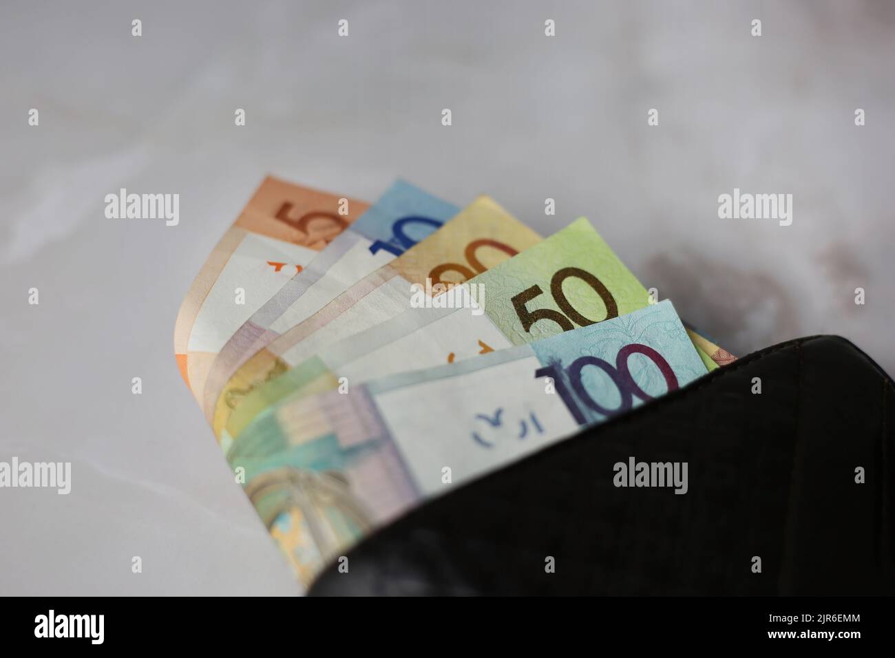 Weißrussische Rubel in einer geschlossenen schwarzen Brieftasche auf grauem Hintergrund Stockfoto