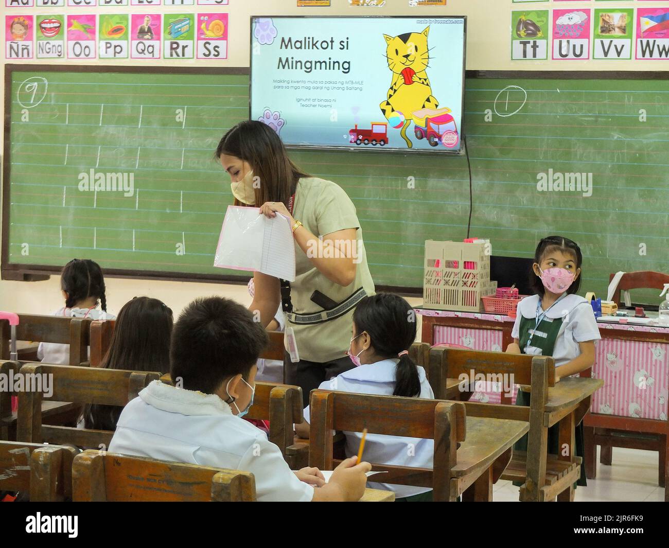 Malabon City, Philippinen. 22. August 2022. Eine Lehrerin sah, wie sie ihrem Schüler beim Schreiben half. Nach zwei Schuljahren ohne Präsenzunterricht werden die leeren Korridore und Klassenräume wieder voll mit Schülern sein, da das Bildungsministerium (DepEd) am Montag, den 22. August, den Beginn des Schuljahres 2022-2023 offiziell eröffnet. (Foto: Josefiel Rivera/SOPA Images/Sipa USA) Quelle: SIPA USA/Alamy Live News Stockfoto