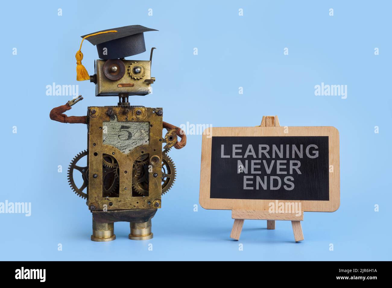 Tafel mit Schild Lernen endet nie und alter Roboter. Stockfoto
