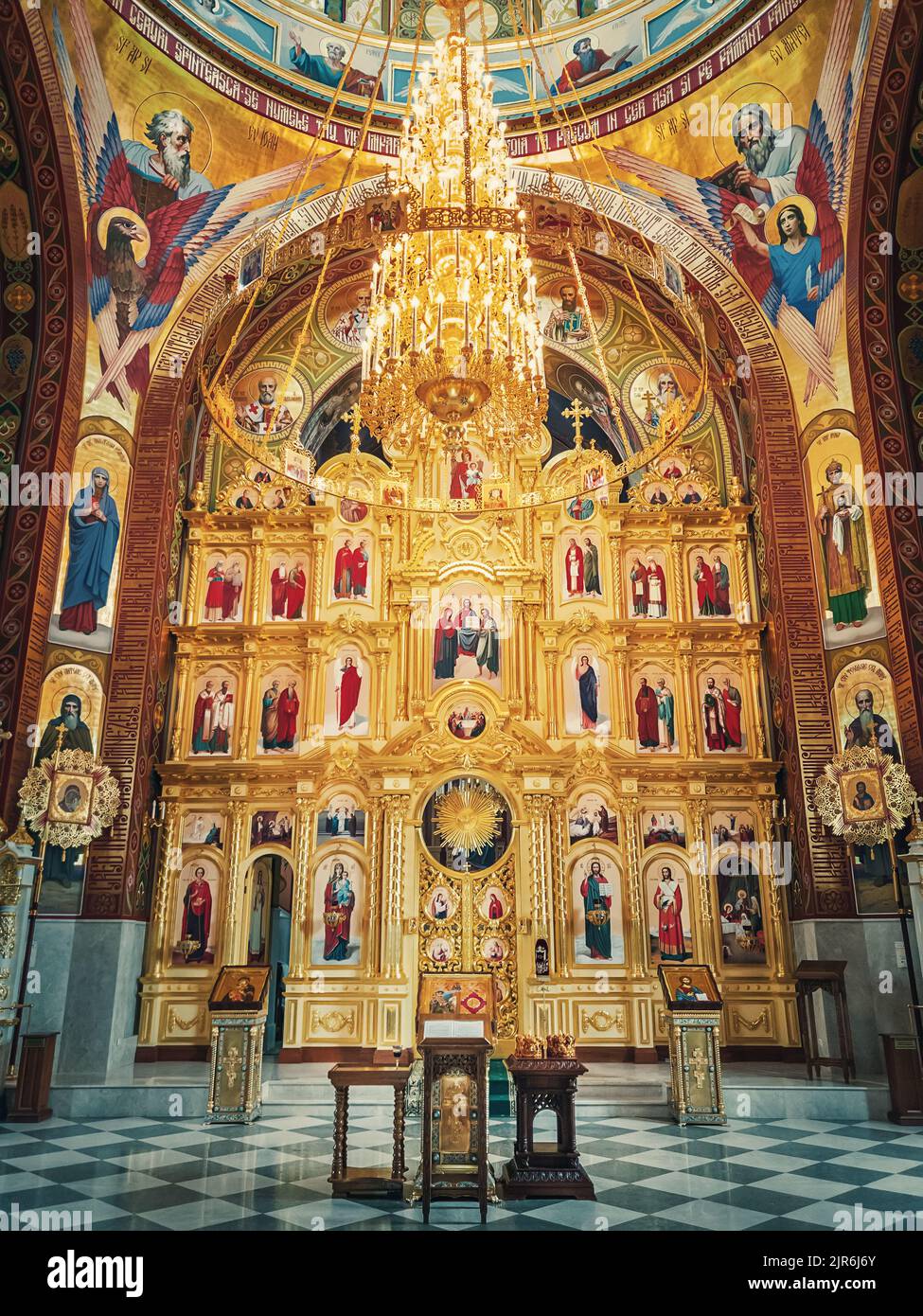 Der Altar und das schöne bemalte Innere des Klosters Curchi. Aufhängebender goldener Kronleuchter mit leuchtenden Lichtern. Verschiedene Ikonen von Heiligen als Tradi Stockfoto